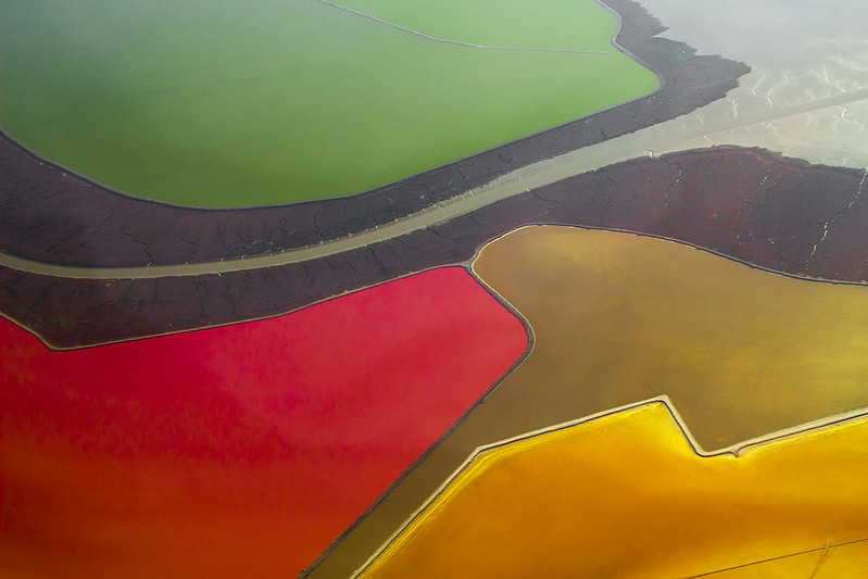 Photo of salt evaporation ponds that Doc Searls flew over on a commercial flight into San Francisco International Airport. The ponds are strikingly colorful, with one green, another red, and two shades of gold.